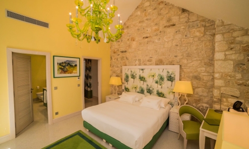 Ein rustikal-modernes Hotelzimmer in Grün und Gelb.