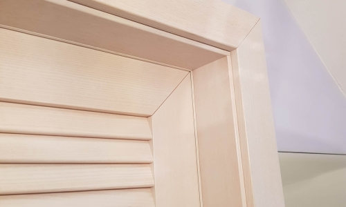 Ein heller Türrahmen aus Holz.