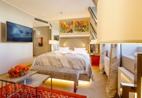Ein großzügiges Hotelzimmer mit großem Bett und Fernseher.