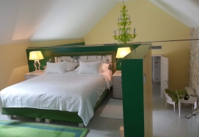 Ein loftartiges Hotelzimmer in Grün- und Gelbtönen.