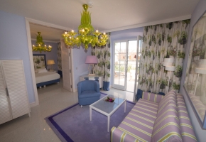 Ein Hotelzimmer in Blautönen mit Terrasse und Sitzgruppe.